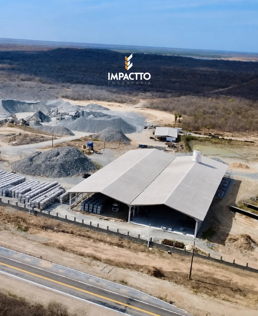 Vista externa da unidade industrial da Impactto, com galpão, pátio e acesso pela rodovia